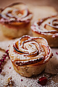 Apple and cinnamon roses made from puff pastry with icing sugar