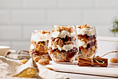 Layered dessert with amarettini, plums, cream and cinnamon