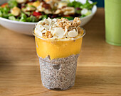 Chia pudding with mango puree, granola and flaked almonds
