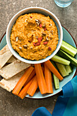 Carrot hummus with vegetable sticks and flatbread