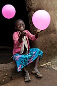 Benin, Nothern distict, Atacora mountains area, Koussoukoingou, girl playing with ballons