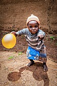 Benin, Nothern distict, Atacora mountains area, Koussoukoingou, child playing with ballons