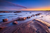 Frankreich, Var, Saint-Raphaël, Sonnenuntergangslichter auf den Felsen des Strandes von Péguière mit dem Massif des Maures im Hintergrund