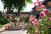 France, Haute Savoie, Rumilly, Vaulx, secret gardens, remarkable garden label, squash fountain and rosebushes in the chestnut yard