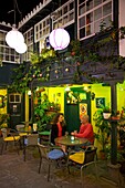 Spain, Canary Islands, Palma Island, Los Llanos de Aridane, couple seated in the colonial patio lit up at night from the restaurant La Luna