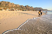 South Africa, Western Cape, Student enjoying sunset at Camps Bay Beach, Cape Town, at the foot of the 12 Apostles Mountains