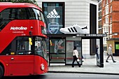 United Kingdom, London, giant shoe perched on a bus shelter for adidas advertising in Oxford street