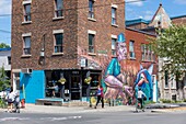 Canada, Province of Quebec, Montreal, Plateau-Mont-Royal neighborhood, Rachel Street, Clandestinos wall by Bruno Smoky and Shalak Attack, Café Névé, cyclist and bystanders