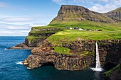 Denmark, Faroe Islands, Vagar Island, Gasadalur, village and waterfall falling into the sea