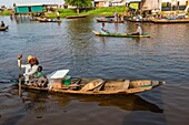 Benin, lakeside city of Ganvié, doughnut shop woman on her dugout