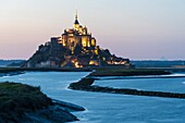 France, Manche, Mont Saint Michel Bay listed as World Heritage by UNESCO, Abbey of Mont Saint Michel and River Couesnon at dusk