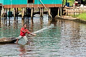 Benin, lakeside city of Ganvié, child throwing his fishing net