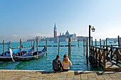 Italien, Venetien, Venedig, von der UNESCO zum Weltkulturerbe erklärt, Gondeln am Becken von San Marco (Bacino di San Marco) mit der Insel und der Kirche San Giorgio Maggiore im Hintergrund