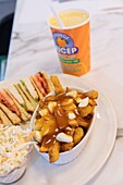 Canada, Province of Quebec, Centre-du-Québec region, in the footsteps of the invention of poutine, Drummondville, Le Roy Jucep restaurant, poutine, club sandwich, and Orange Jucep drink