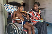 Papua-Neuguinea, Provinz East Sepik, Sepik River Region, Wewak Town, Boram Hospital, Verdacht auf Polio, der junge Nagui Hombi aus dem Dorf Numbogu ist an allen vier Gliedmaßen gelähmt und kann sich ohne Hilfe eines Familienmitglieds nicht bewegen