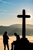 Frankreich, Puy de Dome, Paar am Fuße eines Kreuzes, Regionaler Naturpark Livradois Forez und im Hintergrund der Naturpark der Vulkane der Auvergne