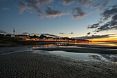 France, Somme, Baie de Somme, Saint-Valery-sur-Somme, Twilight over the village from the Somme channel at low tide