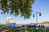 France, Gironde, Bordeaux, area listed as World Heritage by UNESCO, Bordeaux youth under Les Platanes du Quais, cruise ship the Spirit of Discovery moored at the quai des Chartrons