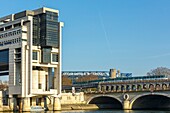 France, Paris, riverbanks of the Seine river listed as World Heritage by UNESCO, building hosting the Ministry of Finances and Economy by architects Paul Chemetov and Borja Huidobro, Bercy bridge over the Seine river and the metro of line 6