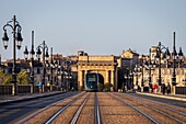 France, Gironde, Bordeaux, area listed as World Heritage by UNESCO, tram on the Pont de Pierre over the Garonne, brick and stone vaulted bridge, in the background the Bourgogne gate