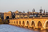 France, Gironde, Bordeaux, area listed as World Heritage by UNESCO, tram on the Pont de Pierre over the Garonne, brick and stone vaulted bridge, in the background the Bourgogne gate