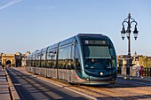 France, Gironde, Bordeaux, area listed as World Heritage by UNESCO, tram on the Pont de Pierre over the Garonne, brick and stone vaulted bridge, in the background the Bourgogne gate