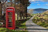 United Kingdom, Scotland, Highland, Inner Hebrides, Isle of Mull west coast, narrow coastal road towards Balnahard, telephone booth converted into a defibrillator post