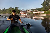 Canada, Province of Quebec, Mauricie region, Hydravion Aventure, Alain Priem founder and president in canoe in front of the hydrobase