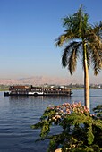 Ägypten,Oberägypten,Niltal,Dampfschiff Sudan,das letzte Dampfschiff auf dem Nil,das den Fluss von einem grünen Ufer aus überquert,mit den Bergen des Tals der Könige als Hintergrund