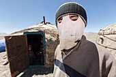 Tajikistan, Gorno-Badakhshan Autonomous Region, yurt camp by M41 road, also called Pamir Highway, portrait of a young Kyrgyz man wearing a mask on his face as a protection from the intense radiation of the sun, altitude 3900m