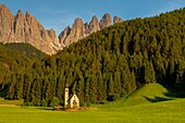 Italy, Trentino-Alto Adige, South Tyrol, Val di Funes, Ranui church with group of Dolomites of Puez Odle (Puez Geisler) in the background