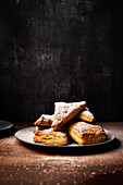 Apple pockets with icing sugar on a wooden surface