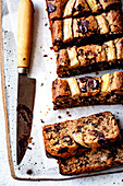 Sliced banana chocolate bread on a chopping board with a knife next to it
