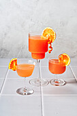 Blood orange margaritas on a tiled table with a grey background