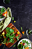 Cooking with herbs and edible flowers concept, with negative space.