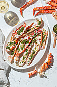 Delicious crab legs garnished with fresh herbs and garlic serve as the focal point of this mouth-watering dish. Paired with white wine, this gourmet meal is both visually appealing and full of flavors