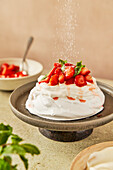 Strawberry and mint pavlova with cream on a grey serving dish