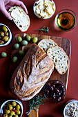Selection of olive products,including Kalamata olive sourdough bread,green olive dip,olive oil,dairy-free olive spread,Sicilian olives and marinated green and black olives