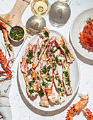 Delicious crab legs garnished with fresh herbs and garlic serve as the focal point of this mouth-watering dish. Paired with white wine, this gourmet meal is both visually appealing and full of flavors