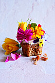Japanisch inspirierter Karotten-Cupcake mit Apfelminze und essbaren Blumen.