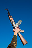 Young man holding a Kalashnikov rifle (AK47), Florence, Tuscany, Italy, Europe