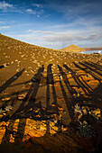 Human shadows on the lava formation and rock forms on the island of Bartolome in the Galapagos Islands, UNESCO World Heritage Site, Ecuador, South America