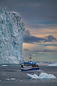 Little boat between the icebergs of the Ilulissat Icefjord, UNESCO World Heritage Site, Western Greenland, Denmark, Polar Regions