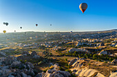 Luftaufnahme von Heißluftballons über Felsformationen bei Sonnenaufgang,Goreme,Goreme Historical National Park,UNESCO-Weltkulturerbe,Kappadokien,Region Zentralanatolien,Anatolien,Türkei,Kleinasien,Asien