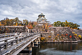 Beautiful Osaka Castle moat in autumn (fall) with bridge leading over the waters towards the Samurai Castle, Osaka, Honshu, Japan, Asia