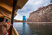 View from a traditional boat on the Osaka Castle Moat and walls in autumn with visitors sightseeing, Osaka, Honshu, Japan, Asia