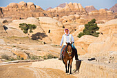 Man riding a horse along the access track to the gorge of Petra, UNESCO World Heritage Site, Jordan, Middle East