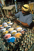 Man pouring colored sands into a decorative bottle, Jordan, Middle East