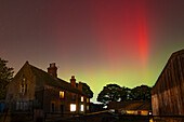 View of Northern Lights (Aurora borealis) and farmhouse near the village of Glapwell, Bolsover, Derbyshire, England, United Kingdom, Europe