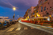 View of bars and restaurants in the fishing port Marina Grande with trail lights at dusk, Procida, Phlegraean Islands, Gulf of Naples, Campania, Southern Italy, Italy, Europe